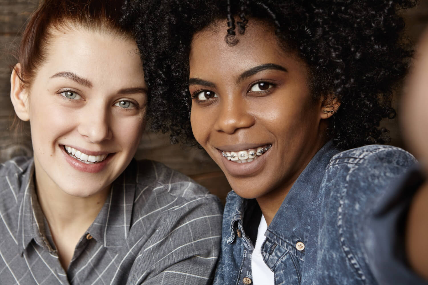Duas mulheres sorrindo: uma com alinhadores invisíveis e outra com aparelho fixo metálico na Só Riso Odontologia em Pato de Minas.